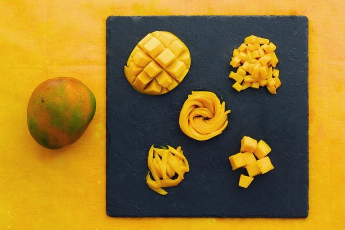 five different ways to cut a mango on a slate cutting board