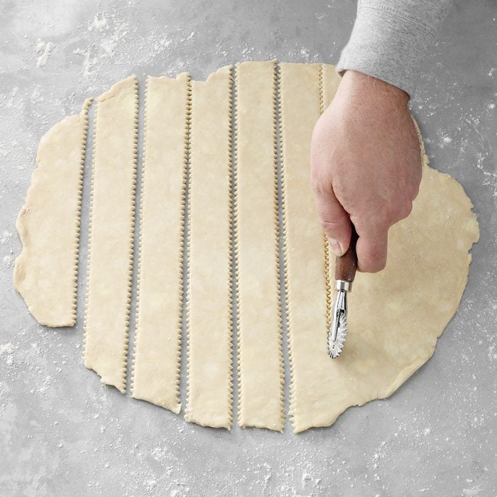 cutting out strips of pie crust dough