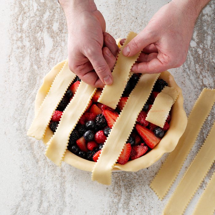folding back some of the lattice strips on top of a pie