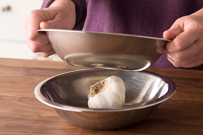 peeling garlic between two metal bowls