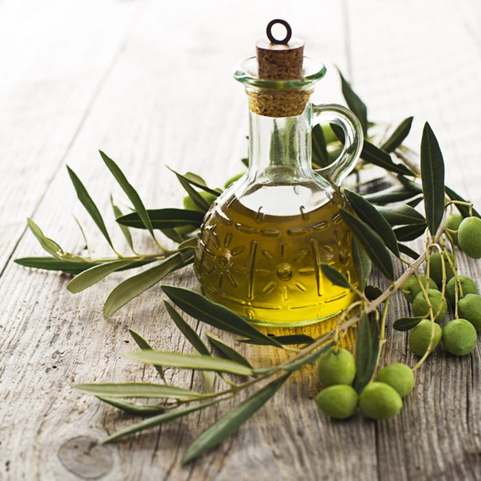Olive oil and olive branch on the wooden table; Shutterstock ID 159233054