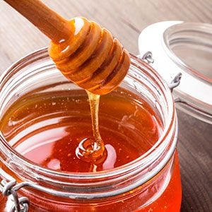 Jar of honey against a wood background