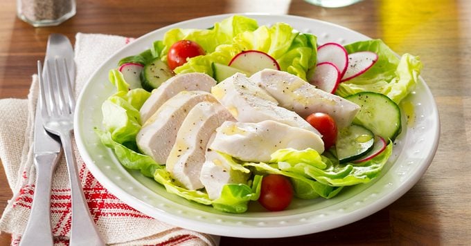Poached chicken on a bed of lettuce and sliced radishes