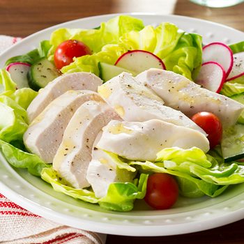 Poached chicken on a bed of lettuce and sliced radishes