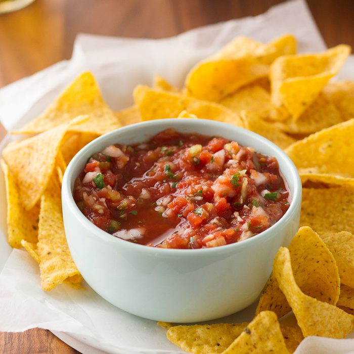 Homemade salsa in a bowl surrounded by tortilla chips