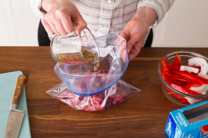 The sliced beef is now in a plastic bag having marinade poured over it