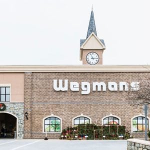 Wegmans grocery store facade and sign with people and Christmas wreath decorations