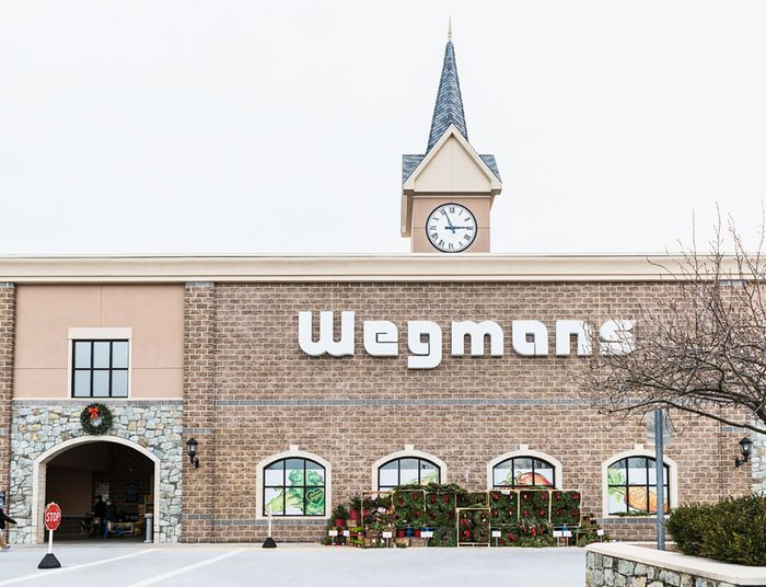 Wegmans grocery store facade and sign with people and Christmas wreath decorations