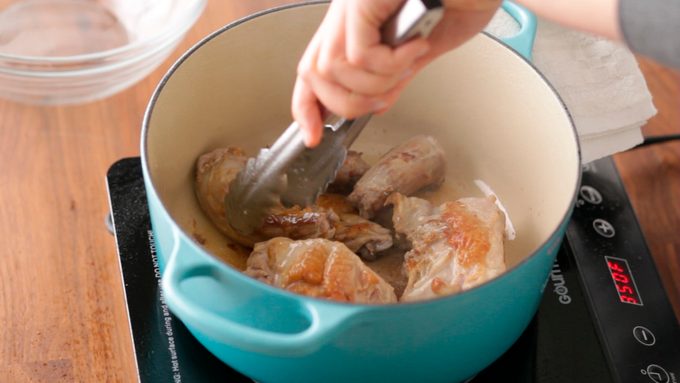 Chicken being flipped in a stockpot