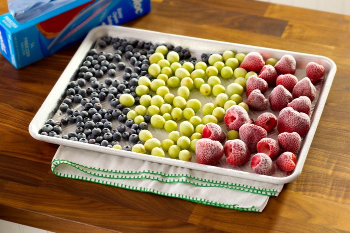 Frozen grapes, blueberries, and raspberries on a baking sheet