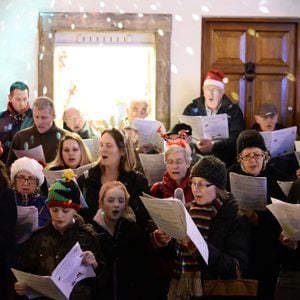 People sing carols at the Christmas Market in the streets surrounding Bath Abbey