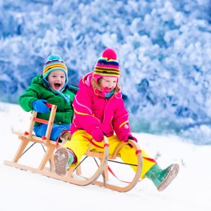 Little girl and boy enjoy a sleigh ride.