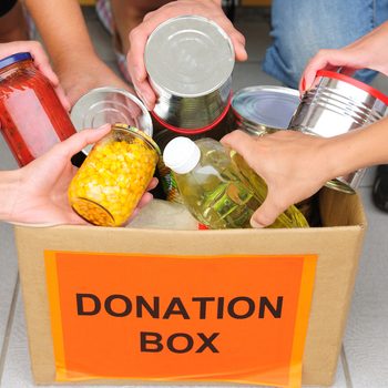 Volunteer putting food in a donation box
