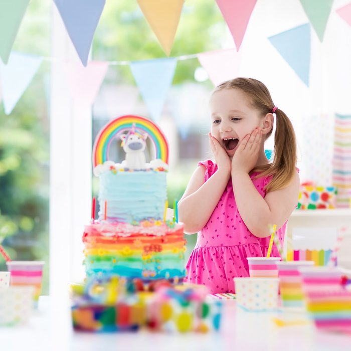 Kids birthday party with colorful pastel decoration and unicorn rainbow cake. Little girl with sweets, candy and fruit. Balloons and banner at festive decorated table for child or baby birthday party.; Shutterstock ID 722010271