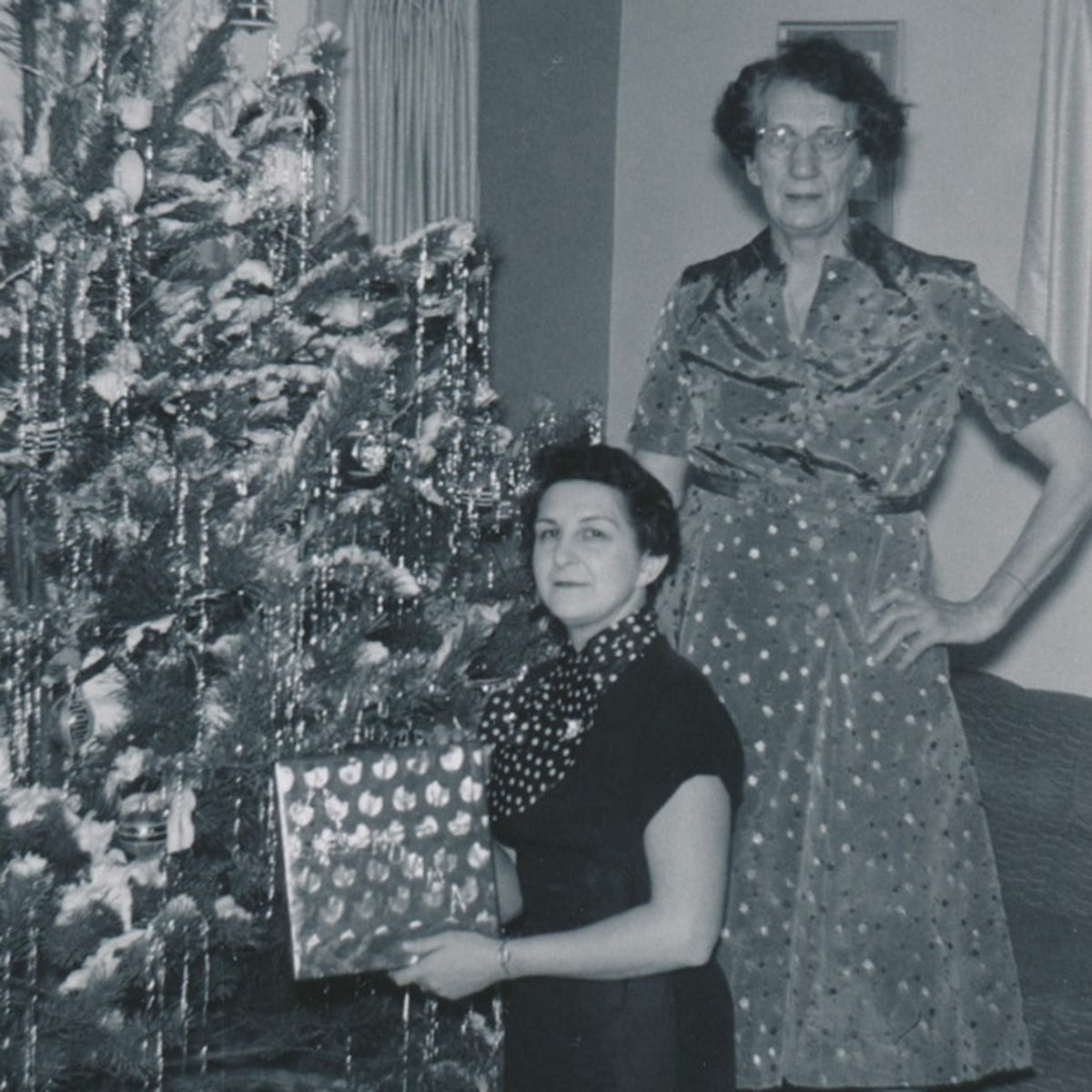 Black and white photo of two women in front of a Christmas tree