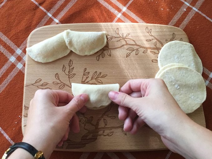 Person carefully pinching the ends of their pierogi shut
