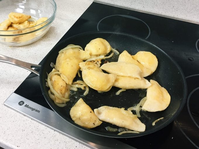 Pierogi being cooked in a skillet on the stovetop