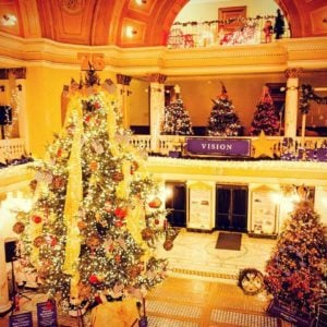 Decorate inside of a building with multiple Christmas trees