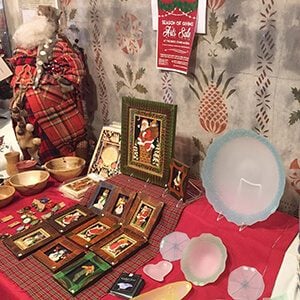 Table of plates and pictures at a holiday craft fair
