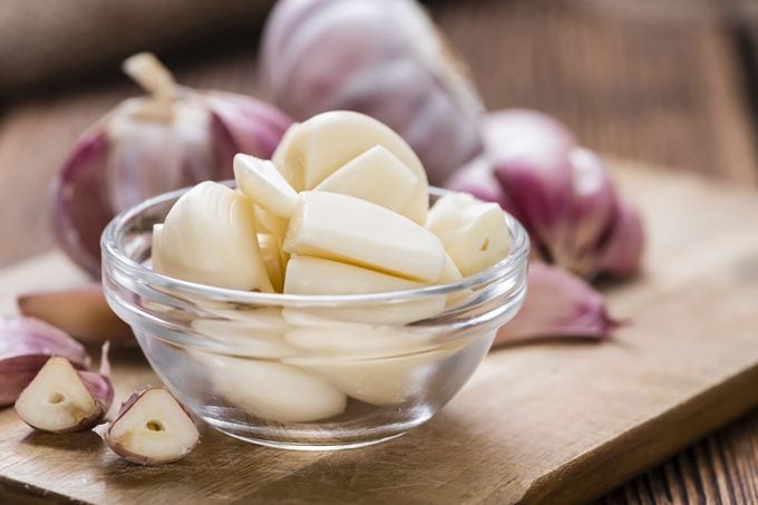 Peeled Garlic (close-up shot) on vintage wooden background