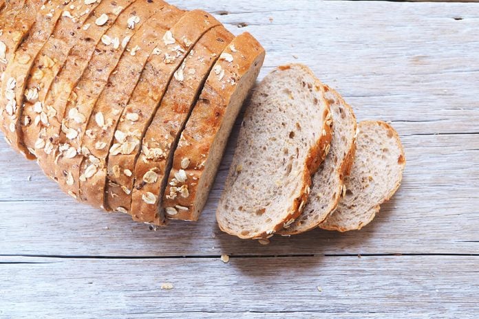 Top view of sliced wholegrain bread on a wooden table.