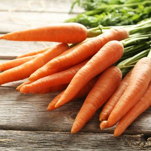 Fresh and sweet carrot on a grey wooden table