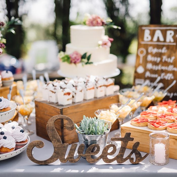 Handmade wooden Sweets sign standing in the middle of the table. Cupcakes, tarts, tartlets, pies and cakes on background. Wedding. Reception. Candy Bar; Shutterstock ID 638964427