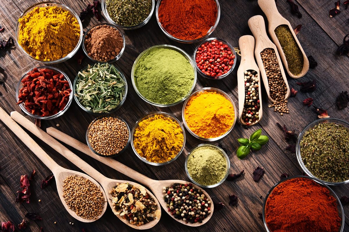 Variety of spices and herbs on kitchen table.