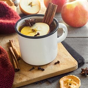 Hot drink of apple tea with cinnamon stick, star anise and clove.