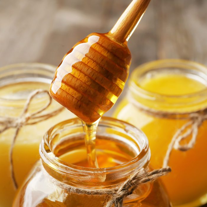 Pouring aromatic honey into jar, closeup; Shutterstock ID 764193367