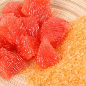 Bowl of grapefruit bath salt and some fresh fruits;