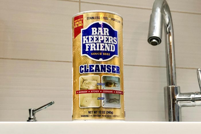 Bar Keepers Friend on a sink ledge in a kitchen