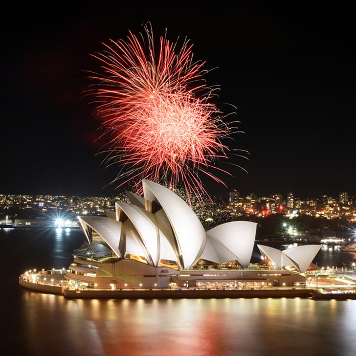 Fiery red fireworks light up the Sydney Opera House and Harbor in a brilliant display