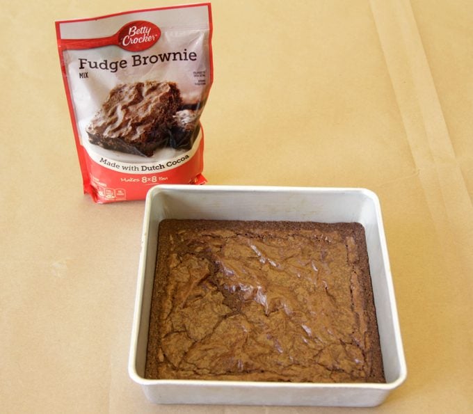 Betty Crocker brand brownies in a pan beside its packaging