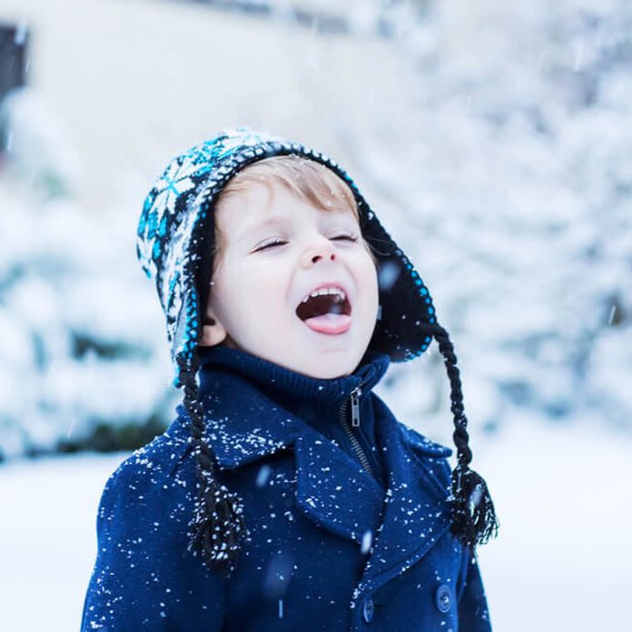 Boy catching snowflakes on his tongue