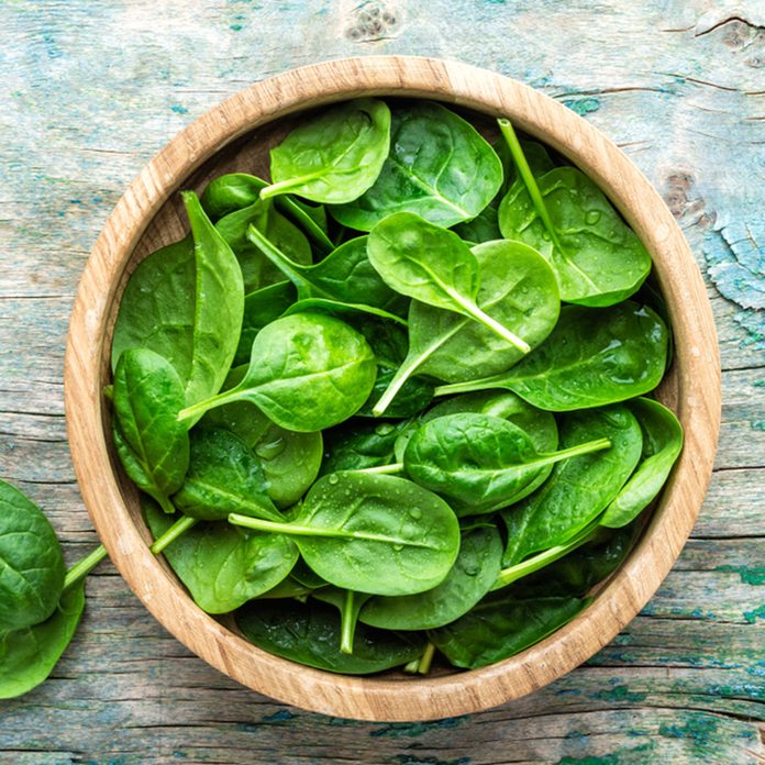 Fresh baby spinach leaves in bowl on wooden background; Shutterstock ID 1022814211; Job (TFH, TOH, RD, BNB, CWM, CM): Taste of Home