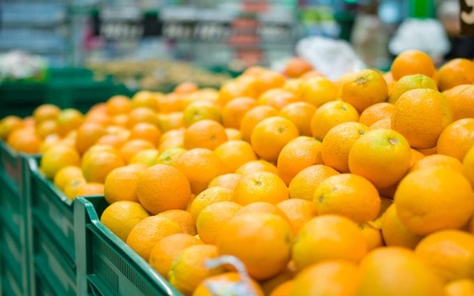 Variety of oranges on boxes in supermarket