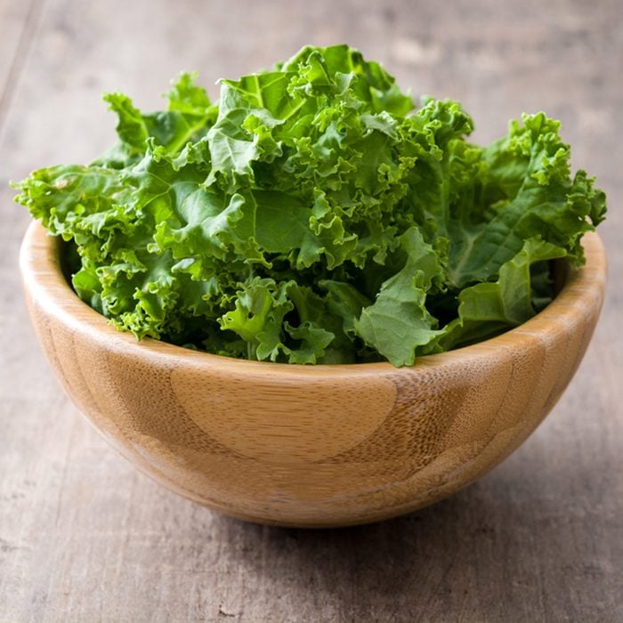 Fresh green superfood kale leaves in wooden bowl on wooden background ; Shutterstock ID 522756688; Job (TFH, TOH, RD, BNB, CWM, CM): Taste of Home