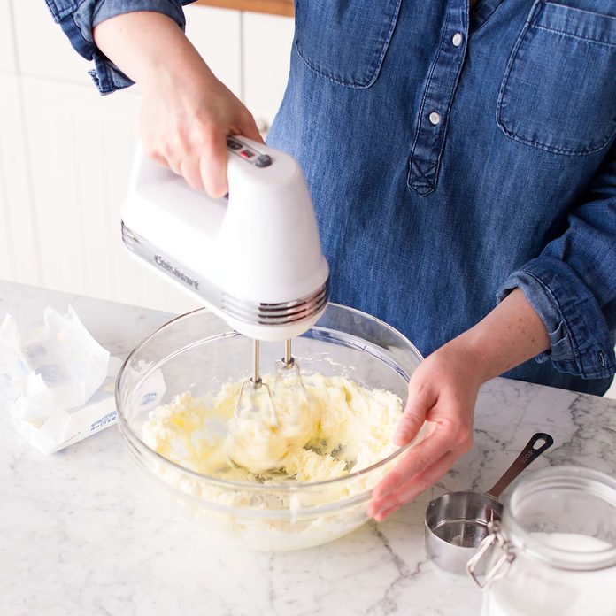 Person using a hand mixer to cream butter and sugar