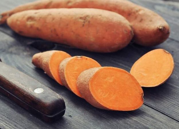 Sliced sweet potatoes beside a knife