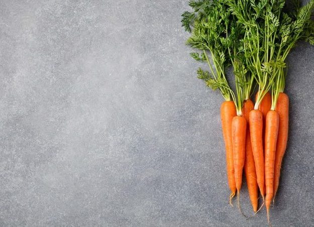 Bunch of carrots against a gray background