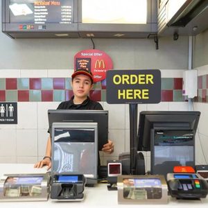 Fast food worker behind the register