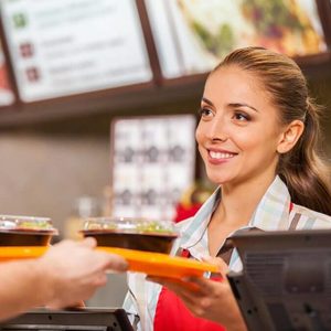 Fast food worker handing a tray of food to a customer