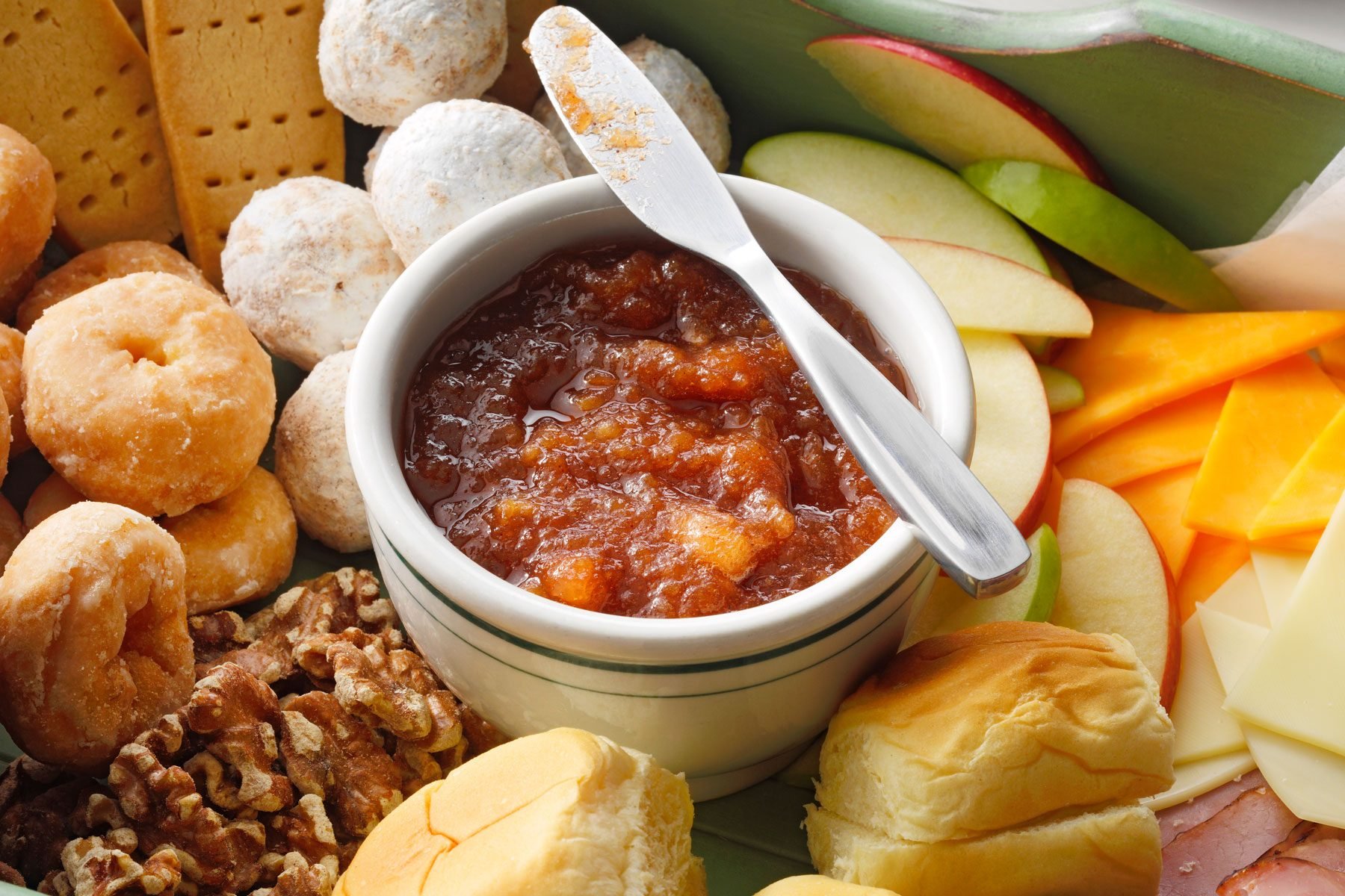 Apple Butter in a bowl with a knife on the top