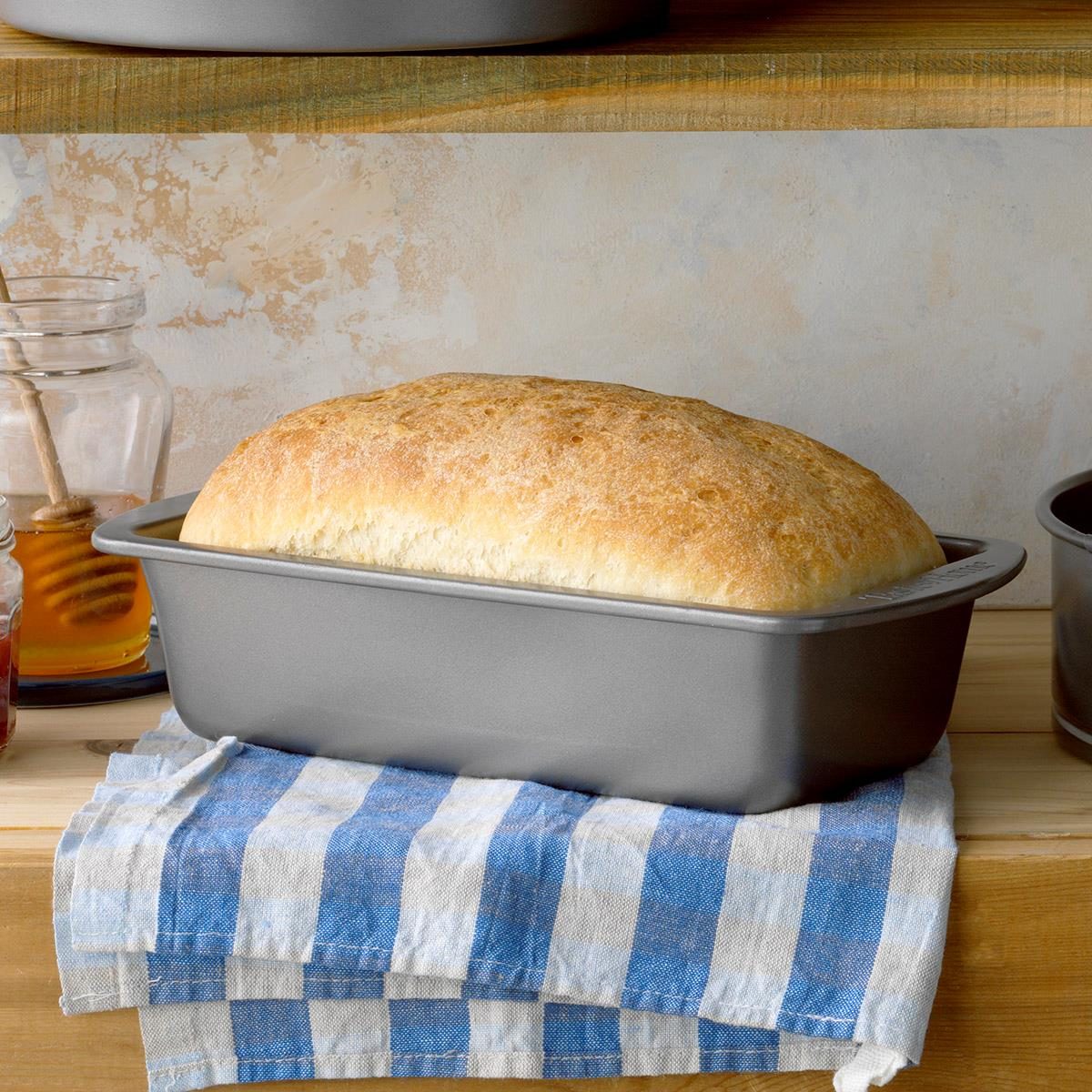 Freshly made loaf of round bread in the black cast iron oven pan