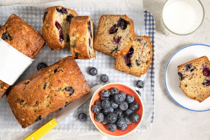 Blueberry Banana Bread on a table with glass of milk