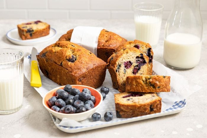 Blueberry Banana Bread served on a table with a glass of milk 
