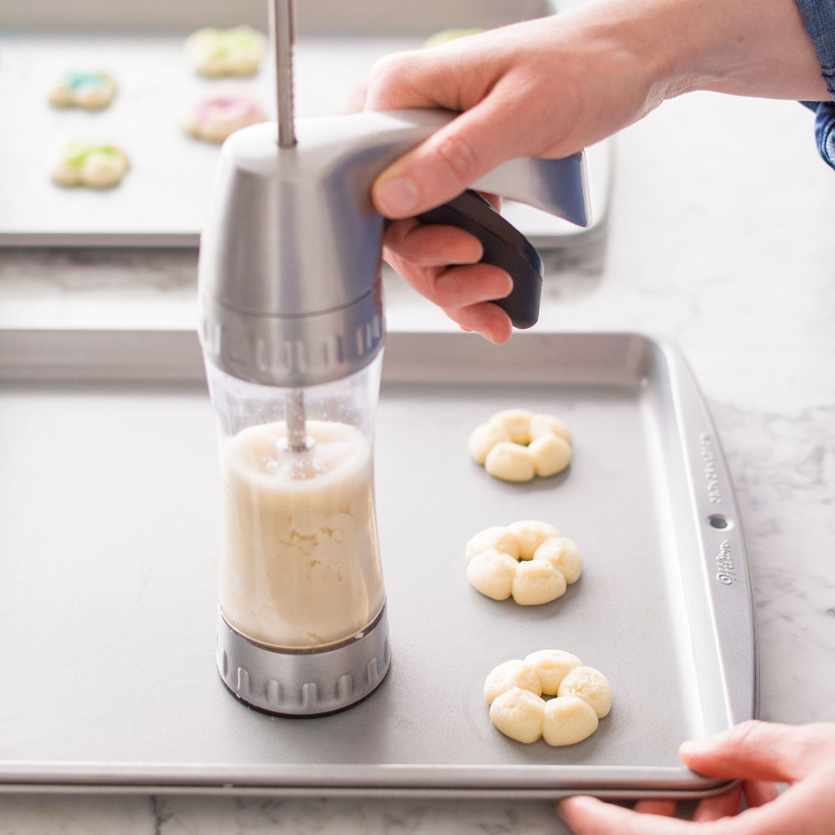 Pressing the Dough onto Baking Tray with Cookie Press to Make Buttery Spritz Cookies
