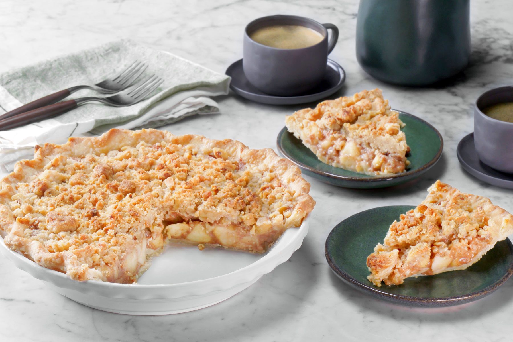 slices of Caramel Apple Pie With Streusel Topping served in a plate with a cp of coffee