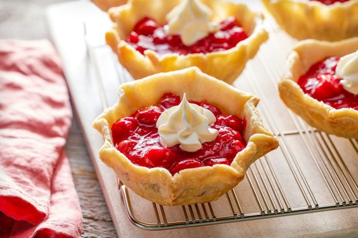 Cherry Tarts on Cooking / Cooling Rack on Wooden Surface